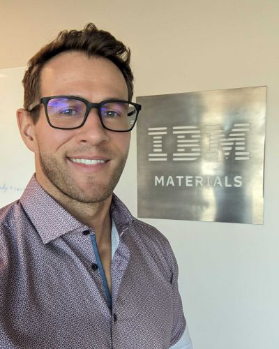 portrait photo of dr Tim Erdmann in front of a "IBM Materials" sign