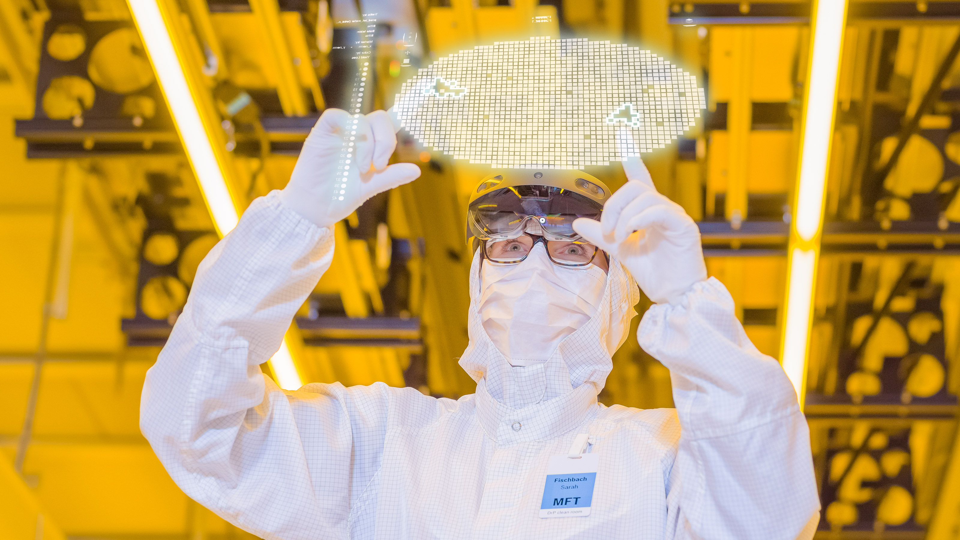 A clean room worker operates a virtual screen on which a wafer with chips can be seen