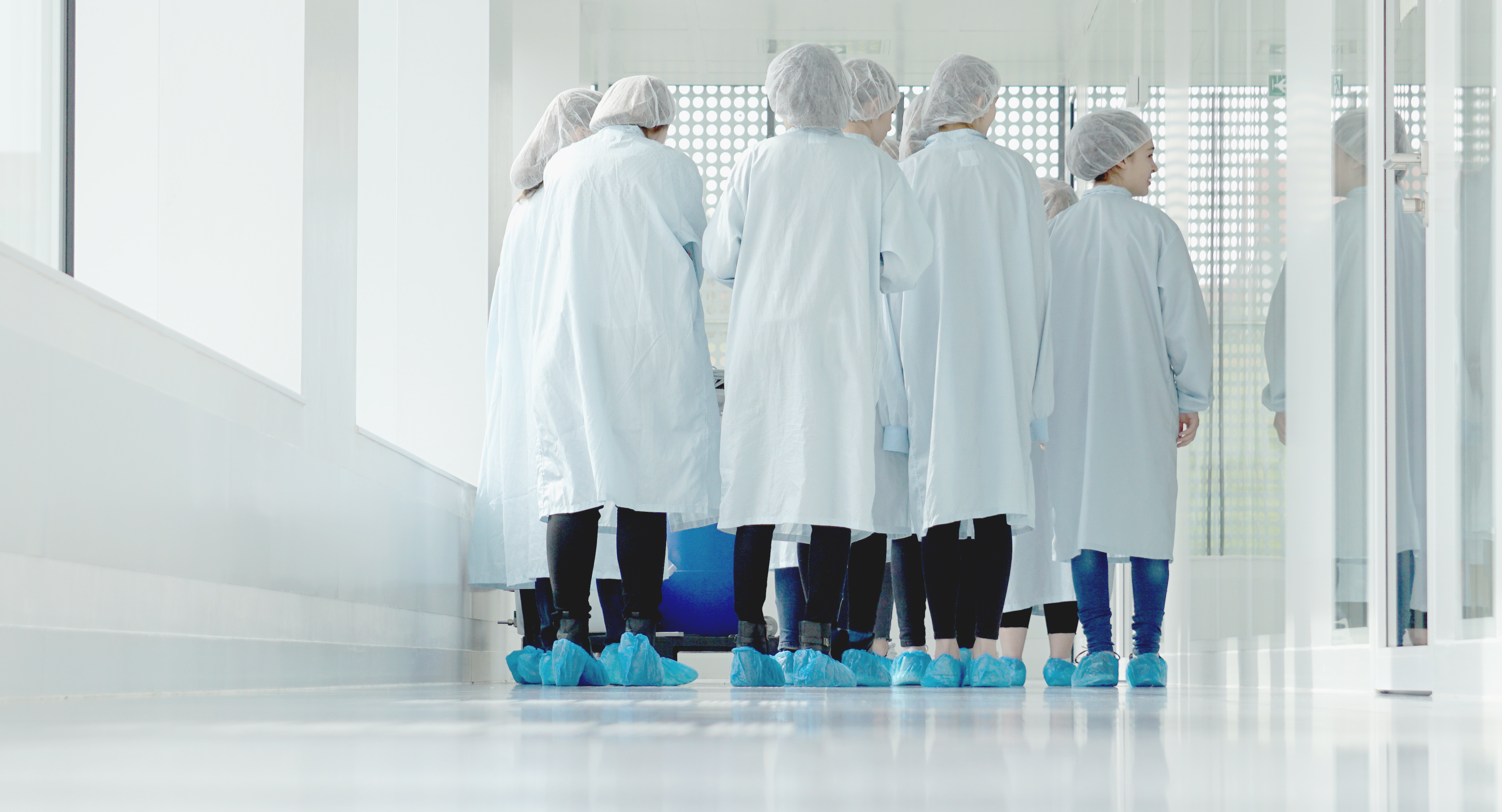 group of students in protective suits walking through a laboratory
